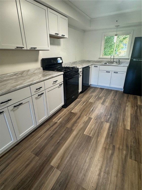 kitchen with black appliances, white cabinetry, and dark hardwood / wood-style flooring