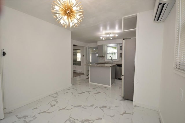 interior space featuring marble finish floor, stainless steel appliances, an AC wall unit, a sink, and baseboards