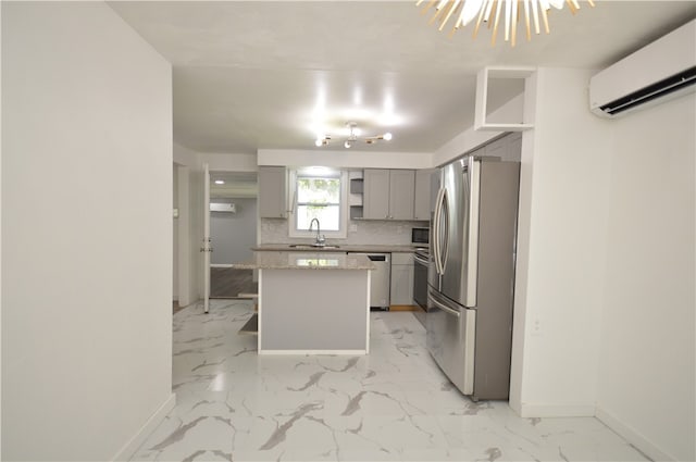 kitchen with stainless steel appliances, backsplash, gray cabinetry, a center island, and light tile patterned floors