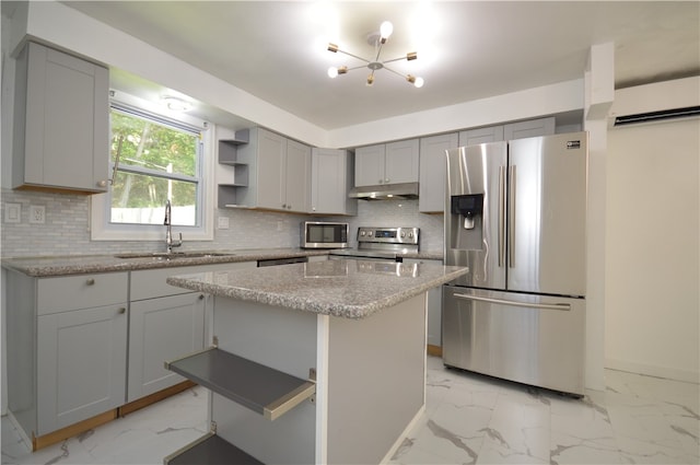 kitchen with decorative backsplash, appliances with stainless steel finishes, light tile patterned floors, a center island, and sink