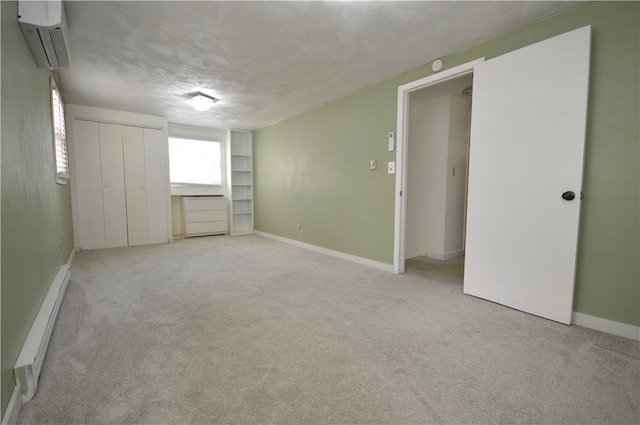 carpeted spare room featuring a baseboard heating unit and a wall mounted air conditioner