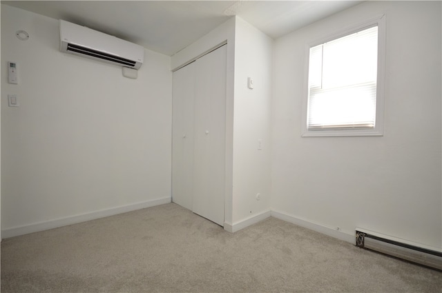 interior space with baseboard heating, an AC wall unit, and light colored carpet