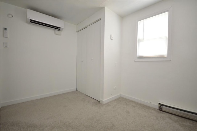 unfurnished room with baseboards, baseboard heating, an AC wall unit, and light colored carpet