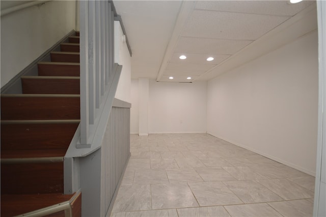 interior space featuring a paneled ceiling and light tile patterned floors