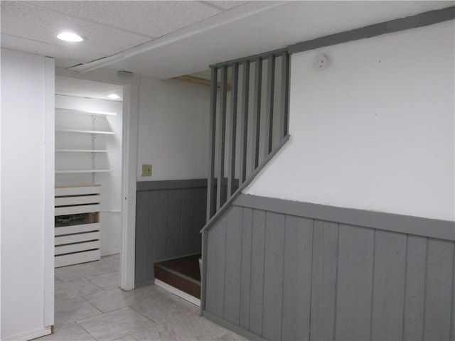 staircase featuring a paneled ceiling and tile patterned floors