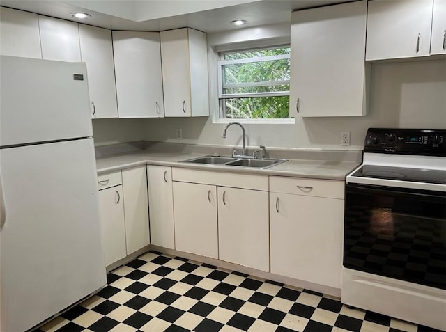 kitchen featuring sink, white appliances, and white cabinetry