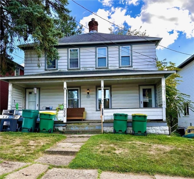 view of front of home with covered porch and a front yard