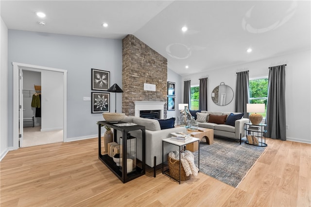 living room with a fireplace, light wood-type flooring, and lofted ceiling