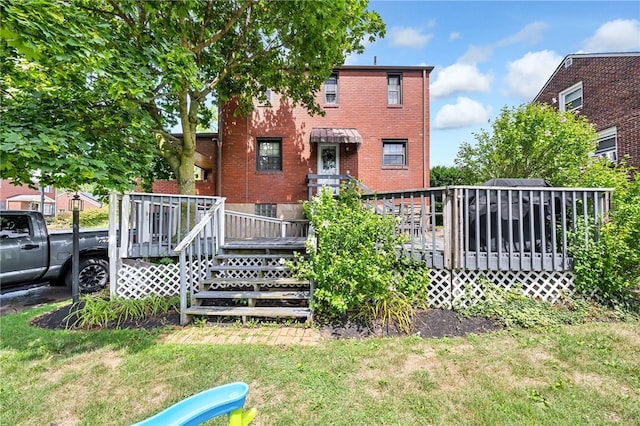 back of property featuring a lawn and a deck