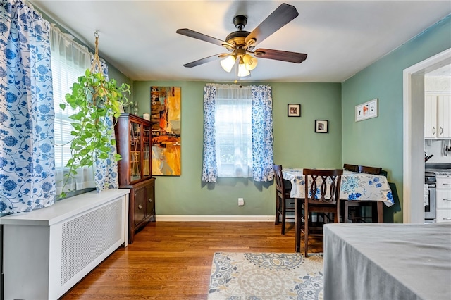 bedroom featuring ceiling fan, radiator, and hardwood / wood-style flooring