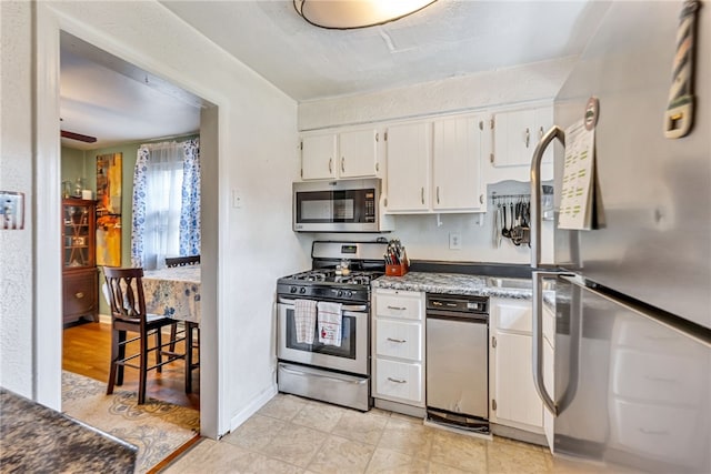 kitchen featuring light wood-type flooring, stainless steel appliances, and white cabinetry