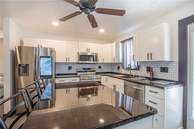 kitchen with stainless steel appliances, hardwood / wood-style floors, ceiling fan, sink, and tasteful backsplash