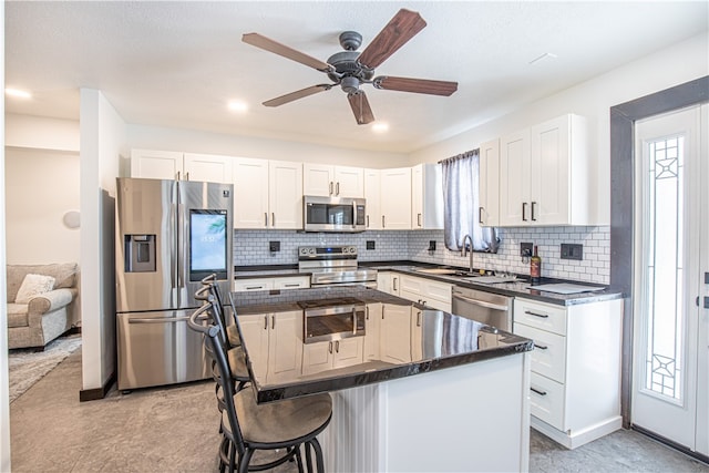 kitchen with ceiling fan, appliances with stainless steel finishes, sink, and white cabinets