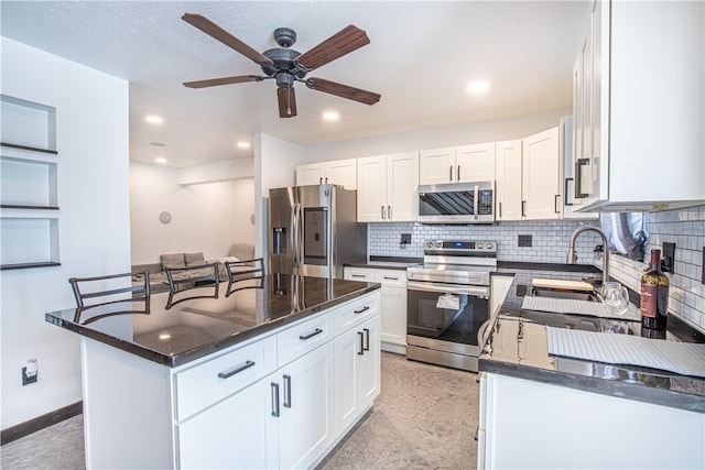 kitchen with sink, light tile patterned floors, stainless steel appliances, and a center island