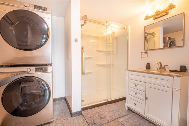 washroom featuring sink, stacked washer and dryer, and light tile patterned floors