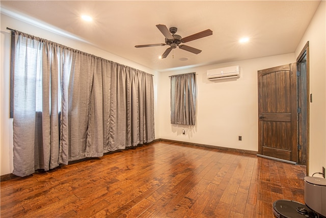 empty room featuring ceiling fan, wood-type flooring, and a wall unit AC