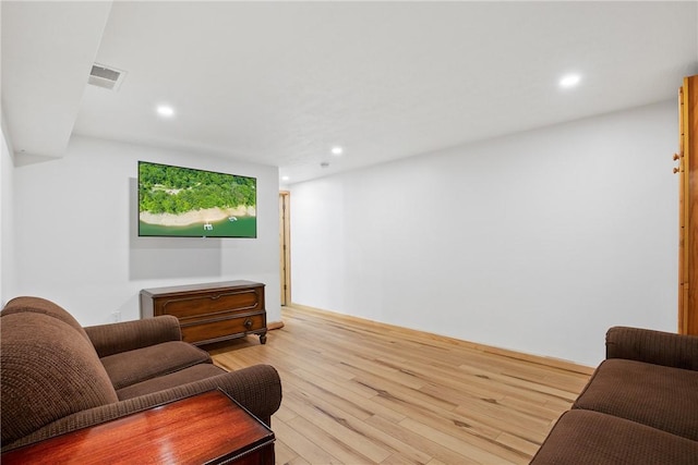 living room with light wood-type flooring, visible vents, and recessed lighting