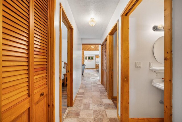 hallway featuring a textured ceiling and light tile patterned flooring