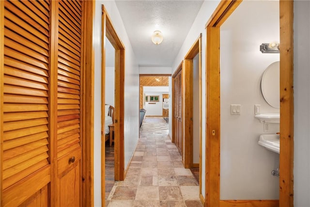 hall with baseboards and stone finish floor