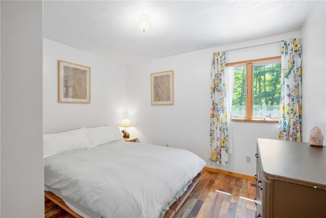 bedroom featuring dark wood-style flooring and baseboards