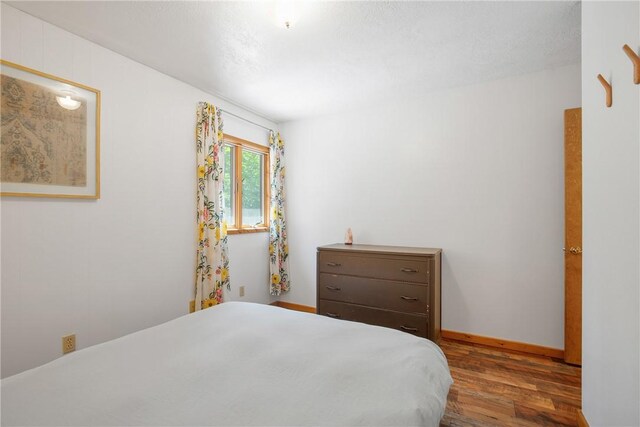 bedroom with dark wood-type flooring