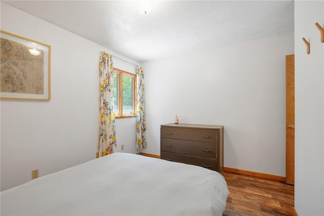 bedroom featuring dark wood-type flooring and baseboards