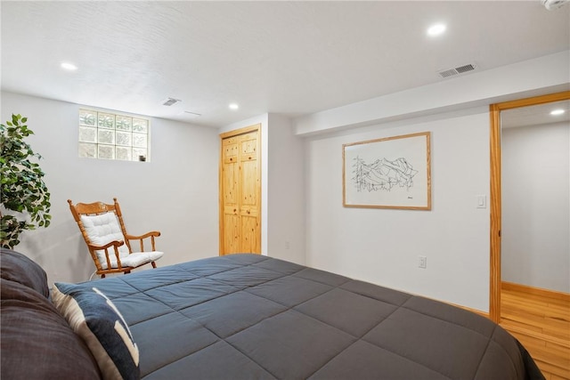 bedroom featuring baseboards, wood finished floors, visible vents, and recessed lighting