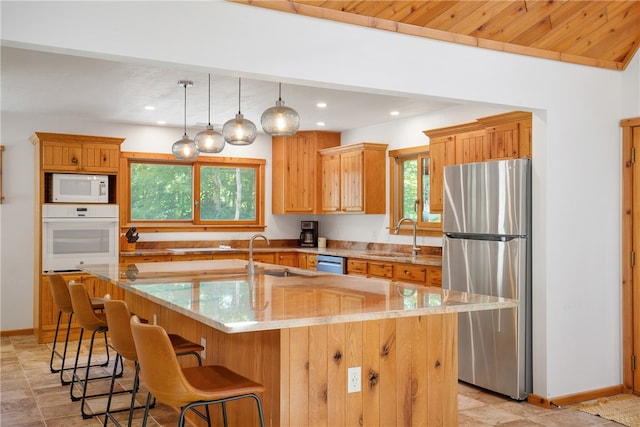 kitchen featuring appliances with stainless steel finishes, a kitchen island with sink, wooden ceiling, and light stone countertops