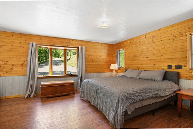 bedroom featuring wooden walls and hardwood / wood-style flooring