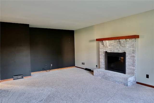 unfurnished living room featuring carpet flooring and a brick fireplace