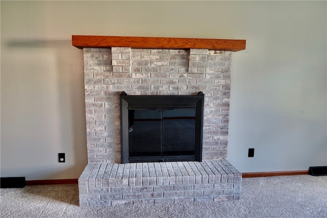 room details featuring carpet and a brick fireplace