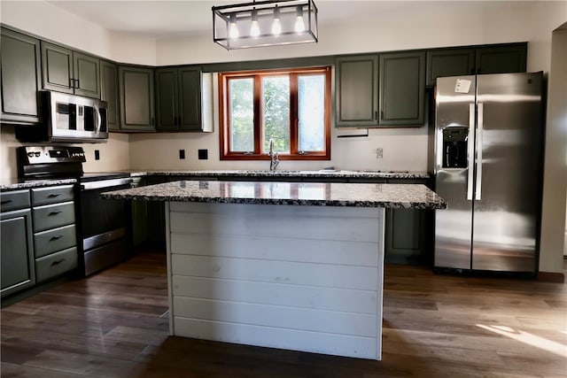 kitchen featuring light stone countertops, a center island, stainless steel appliances, pendant lighting, and dark hardwood / wood-style floors