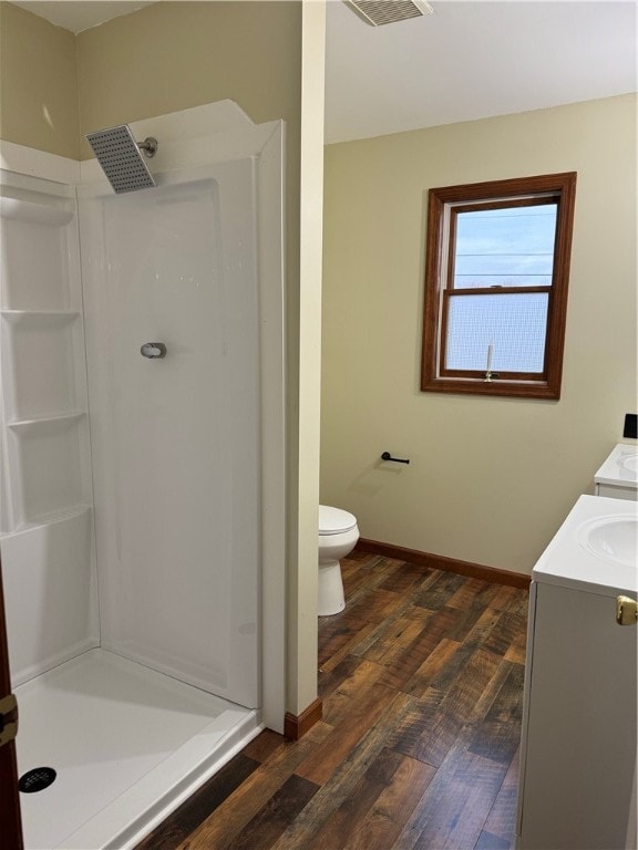 bathroom with toilet, walk in shower, vanity, and wood-type flooring