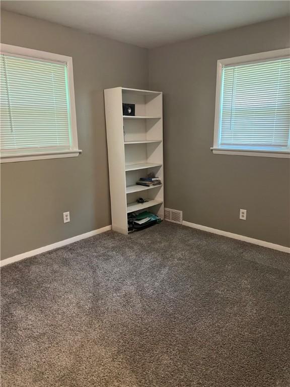 unfurnished bedroom featuring dark carpet