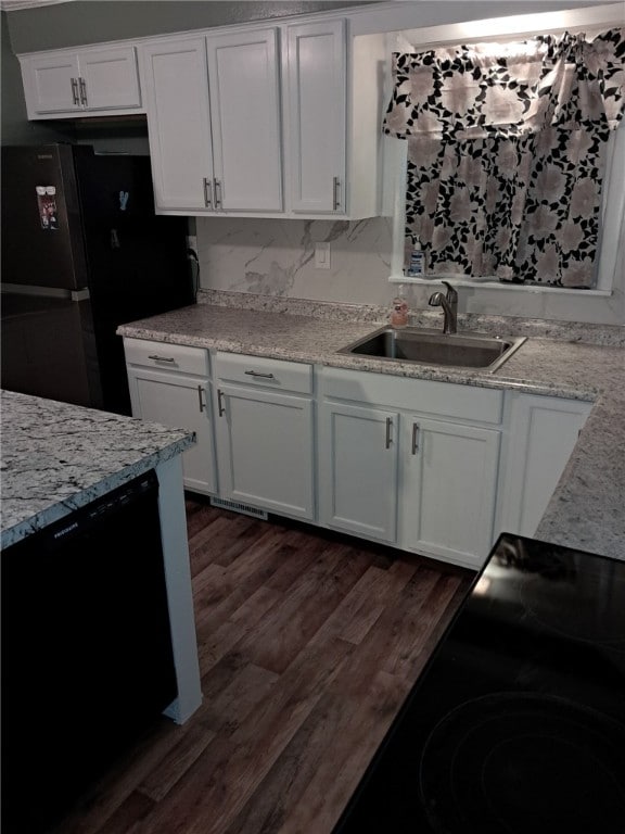 kitchen with tasteful backsplash, black appliances, sink, dark hardwood / wood-style floors, and white cabinetry