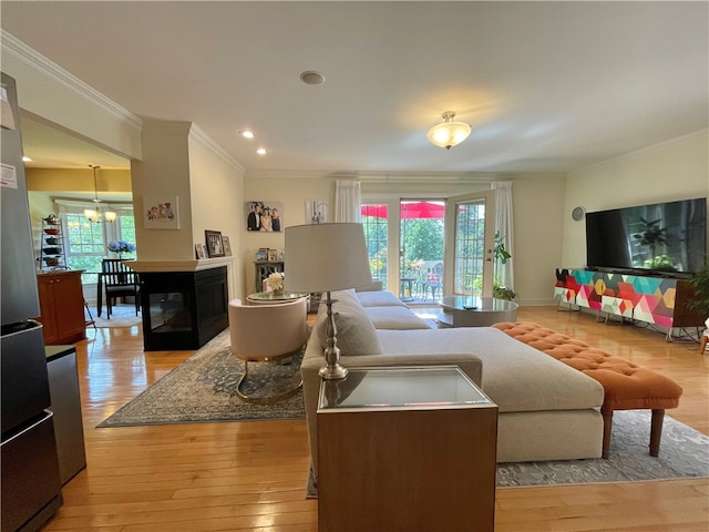 living room with plenty of natural light, light hardwood / wood-style floors, and crown molding