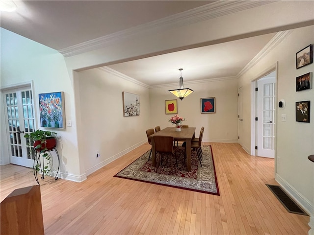 dining room featuring light hardwood / wood-style flooring and ornamental molding