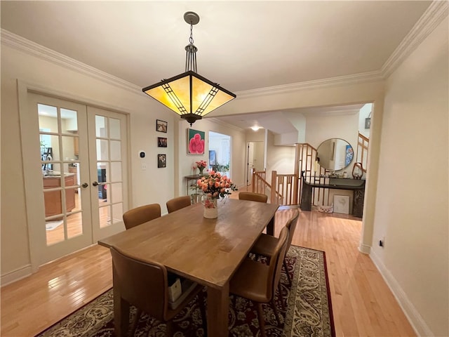 dining room featuring ornamental molding, french doors, and light hardwood / wood-style flooring