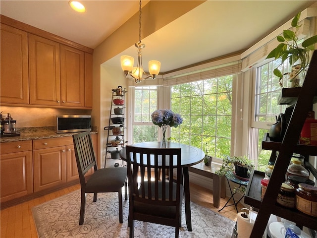 dining room featuring light wood-type flooring and an inviting chandelier