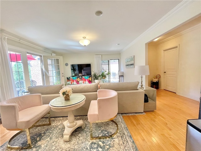 living room with light hardwood / wood-style flooring, a healthy amount of sunlight, and ornamental molding