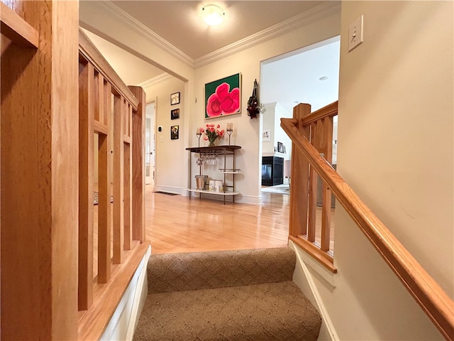 stairs with wood-type flooring and ornamental molding