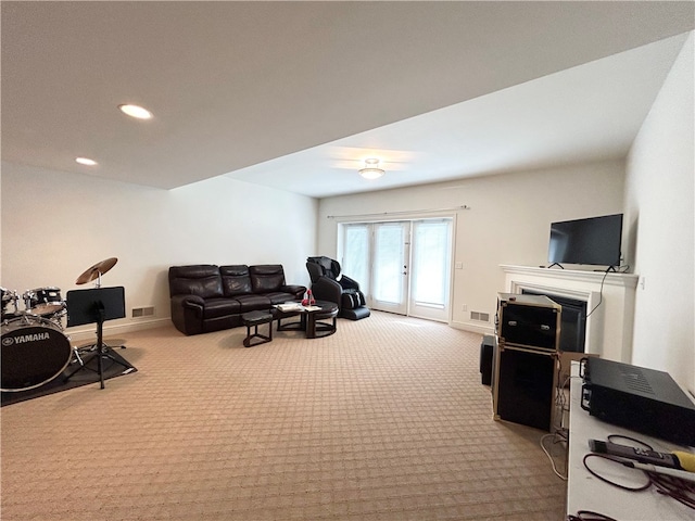 carpeted living room featuring ceiling fan and a fireplace