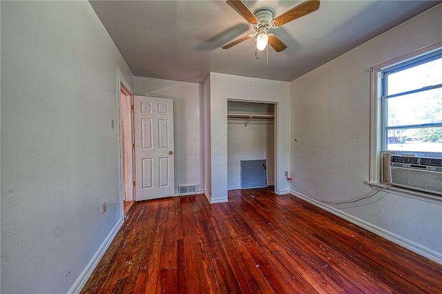 unfurnished bedroom with dark wood-type flooring, a closet, ceiling fan, and cooling unit