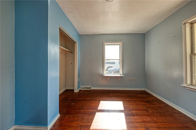 unfurnished bedroom featuring a closet and dark hardwood / wood-style floors