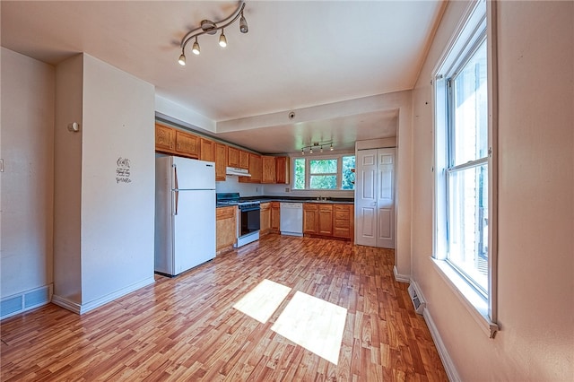 kitchen with sink, white appliances, and light hardwood / wood-style floors