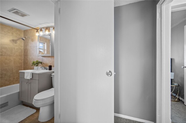 full bathroom with vanity, tiled shower / bath combo, toilet, and tile patterned flooring