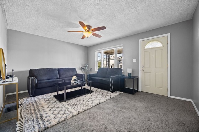 carpeted living room with ceiling fan and a textured ceiling