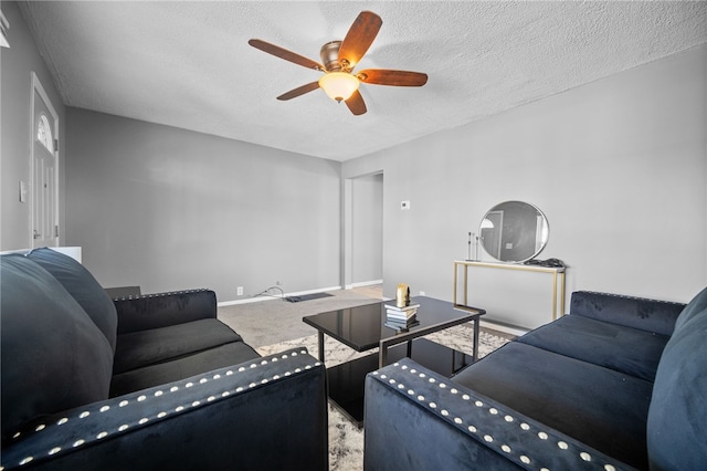 living room with ceiling fan, carpet flooring, and a textured ceiling