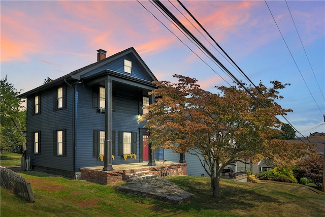 view of front of home with a patio and a lawn