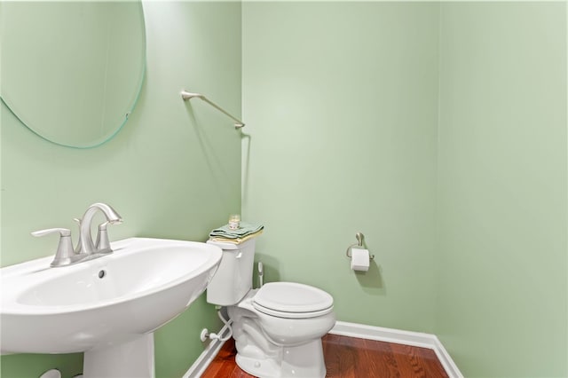 bathroom with hardwood / wood-style floors, sink, and toilet